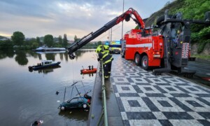 Hasiči vyprošťují auto z řeky pomocí jeřábu a potápěčů
